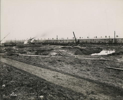 Photograph showing row of terrace houses and cranes